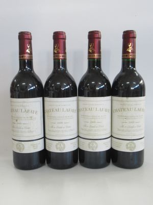 four bottles of wine are lined up on a white surface