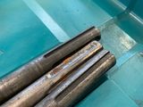 two large metal rods in a blue container on a table