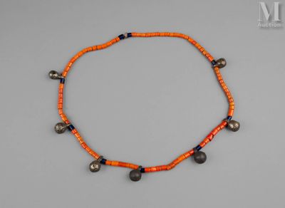 un gros plan d'un collier orné de clochettes posé sur une surface grise
