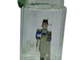 a green glass pitcher with a picture of a soldier on it