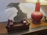 une photo d'une table sur laquelle se trouvent une lampe et une pierre