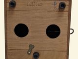 a wooden box with two holes on it