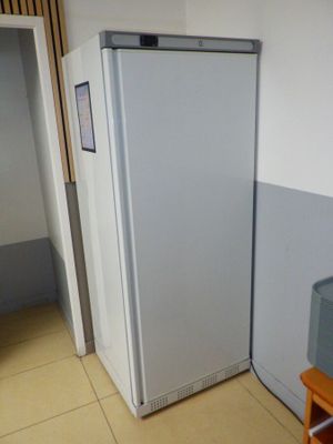 un réfrigérateur blanc dans le coin d'une pièce