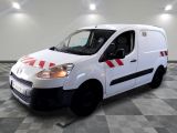 la camionnette blanche est garée sur un sol en damier dans le garage