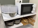 a microwave and a bowl on a shelf in a kitchen