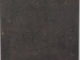 an old book with a black cover sitting on top of a table