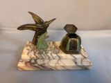 a statue of a bird and a vase on a marble base