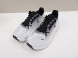the pair of black and white sneakers are on a white surface