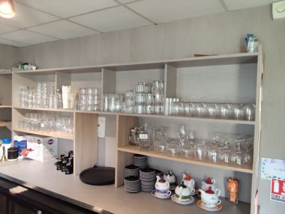 de nombreux verres et tasses sur les étagères de la cuisine