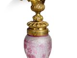 un vase rose avec une anse dorée sur fond blanc