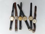 four different types of wrist watches on a white surface