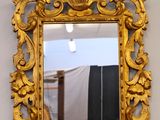 a gold mirror hanging on the wall in a room