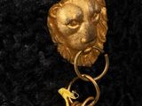 an image of a close up of a black hat with a gold lion head
