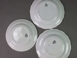 three white plates with designs on them are sitting on a table
