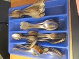 plusieurs cuillères et cuillères à soupe dans un plateau bleu posé sur une table