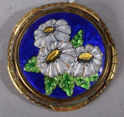 une image représentant une broche sur laquelle sont peintes des fleurs