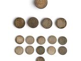 several old coins are arranged in a triangle on a white surface