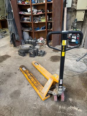 un cariste assis dans un garage, à côté d'une étagère remplie d'outils