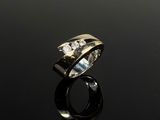 gros plan d'une bague en diamant sur une surface noire