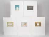 four white cards with gold foil on them are stacked on top of each other