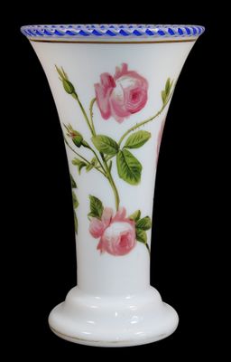 un vase blanc orné de fleurs roses sur fond noir