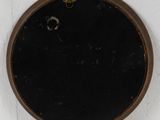 a black and brown clock on the wall next to a white wall