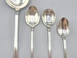 four silver spoons and two silver spoons sitting on a table