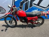 une moto rouge garée devant un mur bleu et blanc