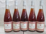 six bouteilles de vin sont alignées sur une table