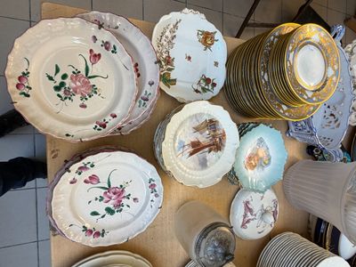 de nombreuses assiettes et bols posés sur une table éclairée par une lampe