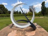 a sculpture of a circular object in the middle of a field