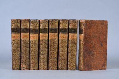 six books are lined up in a row on a gray surface