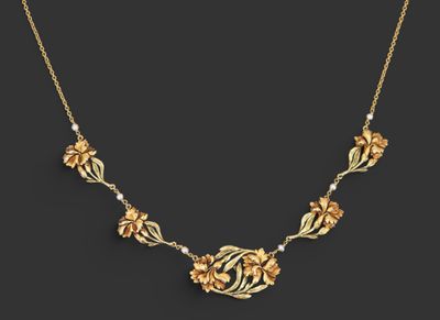un collier en or orné de fleurs et de perles sur fond noir