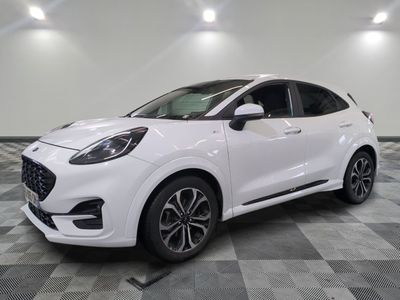 une voiture blanche garée sur un sol en damier dans un garage