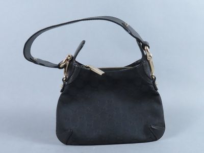 le petit sac à main noir est posé sur une surface blanche