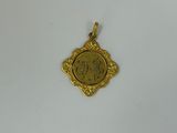 a gold pendant with a picture of a woman on it