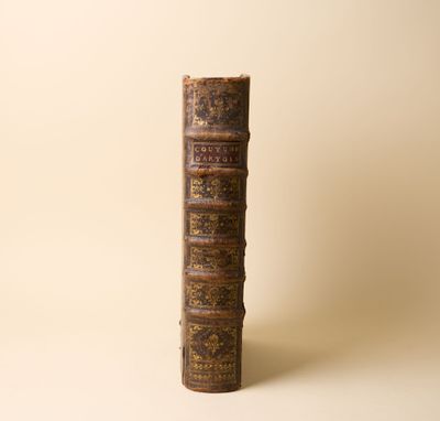 un vieux livre posé sur une table à côté d'un mur
