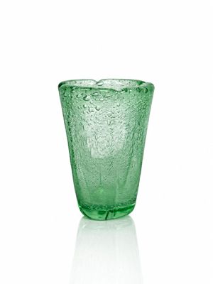 un verre vert posé sur une surface blanche