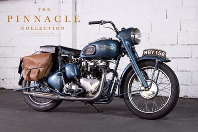 a blue motorcycle parked in front of a white brick wall