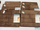 four brown bath mats with labels on them on a bed