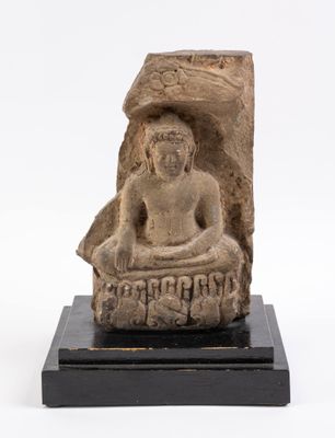 une statue en pierre représentant un Bouddha assis sur un socle noir