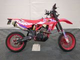 a picture of a red dirt bike parked in a garage