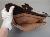 a person holding a brown purse with a white glove