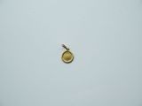 a close up of a small gold pendant on a white surface
