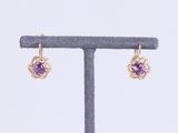 une paire de boucles d'oreilles en améthorate et diamants, présentées sur un présentoir