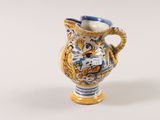 a small blue and white vase with a yellow handle