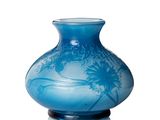 un vase bleu posé sur une surface blanche
