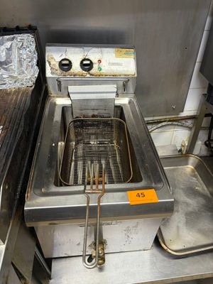 une friteuse au milieu d'une cuisine remplie de nourriture