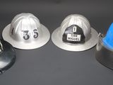 three fire hats sitting next to each other on a table