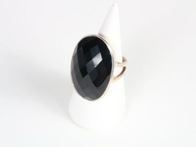 a close up of a ring with a black stone on it